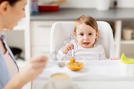 家庭,食物,早餐人们的快乐的母亲,咖啡杯小婴儿坐高椅子上,家里的厨房吃泥快乐的母亲婴儿家里吃早餐图片