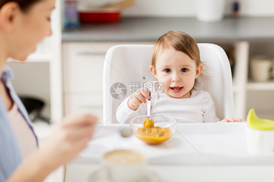 家庭,食物,早餐人们的快乐的母亲,咖啡杯小婴儿坐高椅子上,家里的厨房吃泥快乐的母亲婴儿家里吃早餐图片