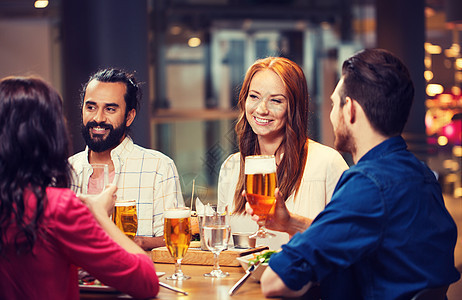 休闲,饮食,食物饮料,人假日的微笑的朋友餐馆酒吧吃晚餐喝啤酒朋友们餐馆吃饭喝啤酒背景图片