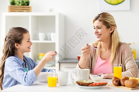 健康饮食,家庭人的快乐的母亲女儿家里的厨房吃早餐幸福的家庭家里的厨房吃早餐图片