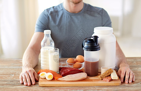 运动营养,健康饮食人的密切的男手与富含蛋白质的食物木制切割板把食物中富含蛋白质的人关来图片