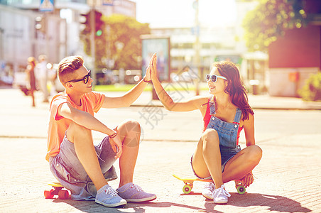 暑假,极限运动,手势人的快乐的十几岁的夫妇与短的现代巡洋舰滑板城市街道上高五轻夫妇城市街道上滑板图片