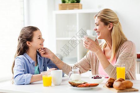 健康饮食,家庭人的快乐的母亲女儿家里的厨房吃早餐幸福的家庭家里的厨房吃早餐图片