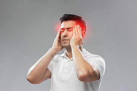 痛苦压力的幸的人,头部疼痛,触摸他的太阳穴灰色的背景幸的人头痛背景