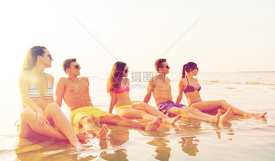 友谊,海洋,暑假,假期人们的群微笑的朋友穿着泳装太阳镜坐海滩上的水中夏天海滩上戴着太阳镜的微笑的朋友图片