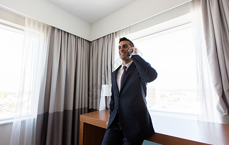 商务旅行,人沟通商人打电话酒店房间的智能手机商人酒店房间打电话给智能手机图片