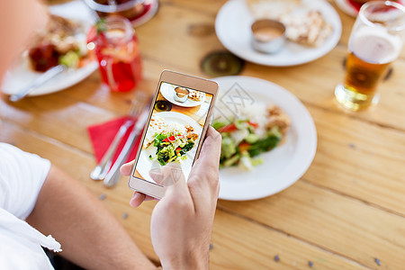 技术,饮食人的手与智能手机拍照食物餐厅手智能手机餐厅想象食物背景图片