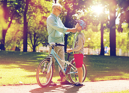 家庭,世代,安全人的快乐的祖父男孩,自行车自行车头盔夏季公园祖父男孩夏季公园骑自行车图片