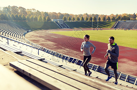 健身,运动,锻炼生活方式的幸福的夫妇跑楼上的体育场幸福的夫妇体育场楼上跑步图片