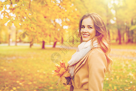 季节人的美丽的轻女人带着枫叶走秋天的公园里秋天公园里枫叶的漂亮女人图片