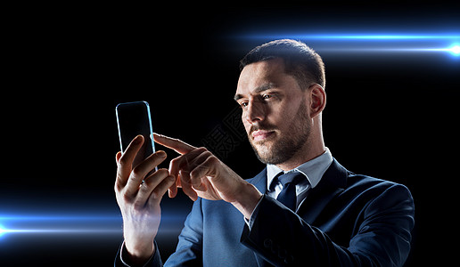 商业,增强现实未来的技术适合与透明智能手机黑色背景下工作的商人拥透明智能手机的商人图片