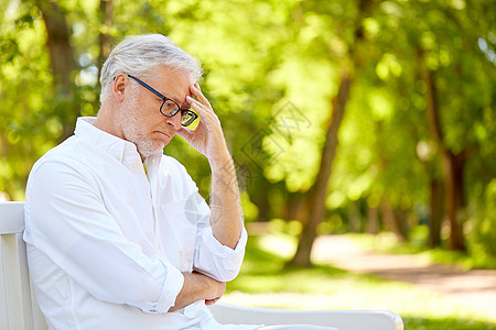 老,退休人们的体贴的老人戴着眼镜,坐夏季公园的长凳上坐夏季公园的体贴的老人背景图片
