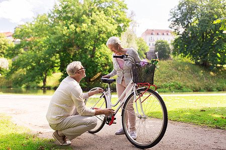 老,人生活方式的快乐的老夫妇与固定自行车夏季城市公园快乐的老夫妇夏季公园骑自行车图片
