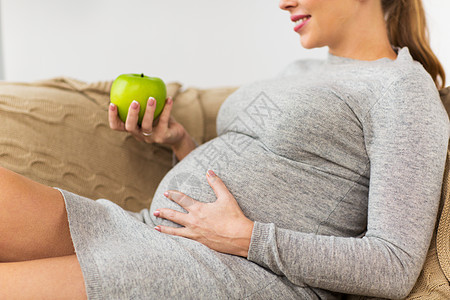 怀孕,健康食品人们的接近快乐的孕妇家吃绿苹果快乐的孕妇家吃绿苹果图片