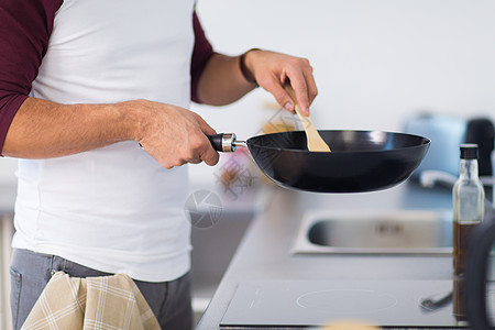 健康的饮食,烹饪人的接近男人与煎锅烹饪食物家里厨房家里厨房里煎锅烹饪食物的男人图片