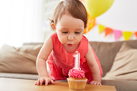 童,人庆祝快乐的女婴蜡烛与纸杯蛋糕生日聚会家里生日时蜡烛的女孩图片