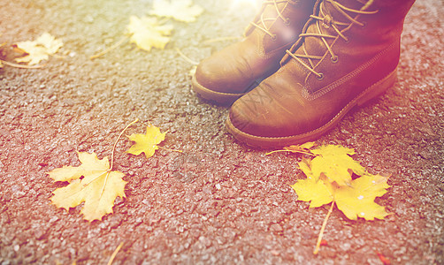 季节,鞋类人的女脚靴子与秋天的叶子地上穿着靴子秋叶的雌脚图片