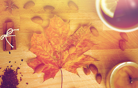 木板上的杯子秋季民族科学柠檬茶蜂蜜木板上与枫叶杏仁木板上的柠檬茶蜂蜜背景