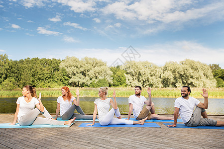 瑜伽,健身,运动健康的生活方式群人坐半的鱼主户外的垫子上,河流湖泊泊位人们瑜伽的半主人的鱼姿势图片