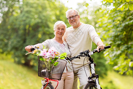 老人,人生活方式的快乐的老夫妇与自行车夏季城市公园快乐的老夫妇夏季公园骑自行车图片