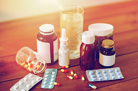 医疗保健医药制药药物药丸鼻喷雾剂退热糖浆木桌上的璃木制桌子上的药物药物图片