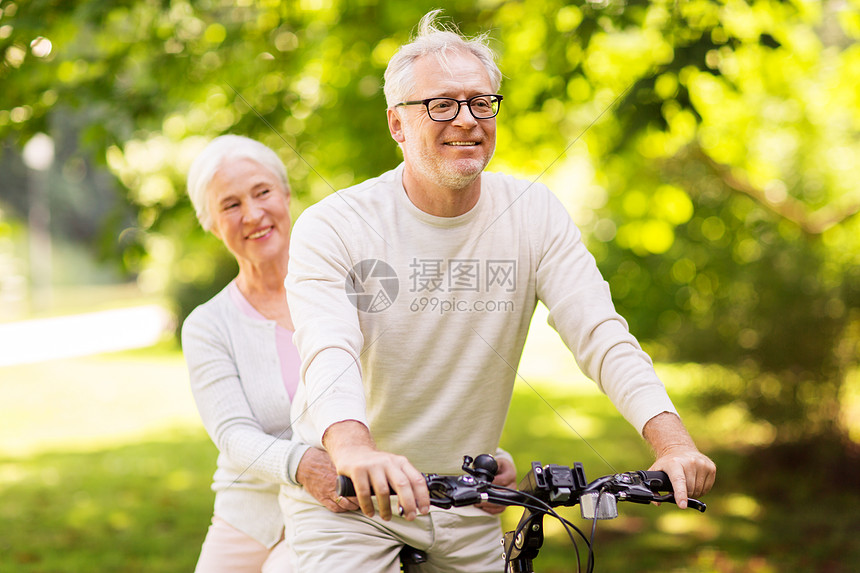 老人,人生活方式的快乐的老夫妇骑辆自行车夏季城市公园快乐的老夫妇公园骑自行车图片