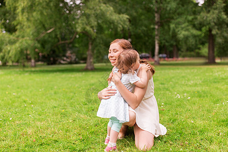 家庭,童父母的快乐的母亲拥抱小女婴夏季公园快乐的母亲夏天的公园拥抱女婴户外高清图片素材