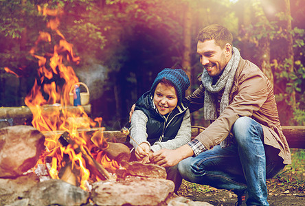 徒步旅行,旅游人们的快乐的父子烤棉花糖超过篝火父子俩篝火上烤棉花糖图片