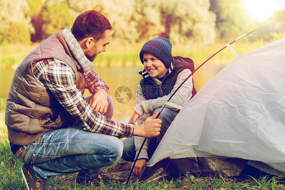 旅游,旅游徒步旅行的快乐的父子徒步旅行户外搭建帐篷快乐的父子户外搭帐篷图片