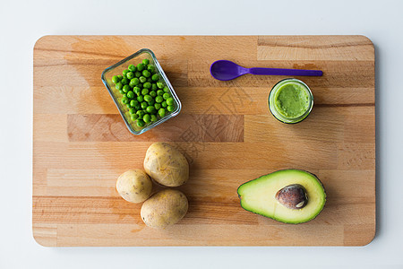 婴儿食品,健康饮食营养璃罐与绿色蔬菜泥喂养勺子木板上木板上的蔬菜泥婴儿食品图片