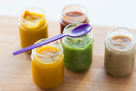 婴儿食品,健康饮食营养打开璃罐的蔬菜水果泥喂养勺子木板上罐子里的蔬菜水果泥婴儿食品图片