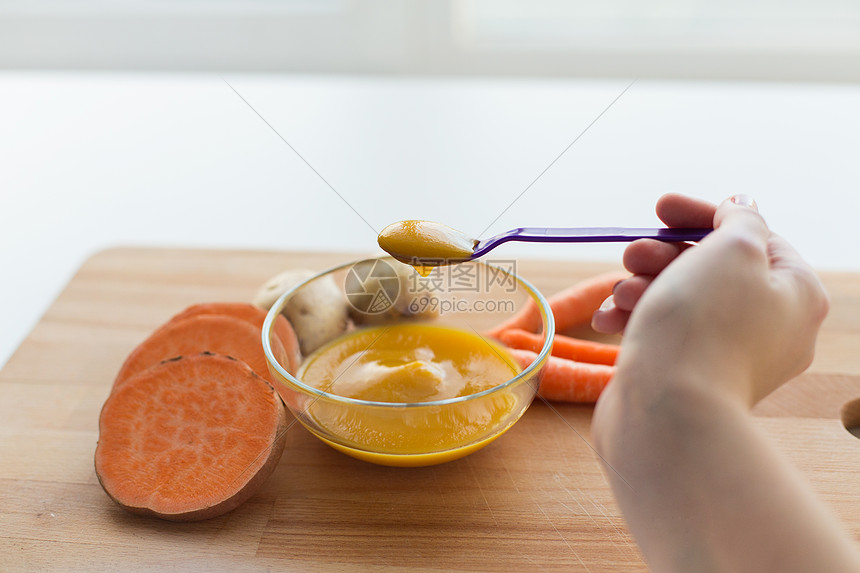 婴儿食品,健康饮食营养手与蔬菜泥喂养勺子用勺子蔬菜泥婴儿食品图片