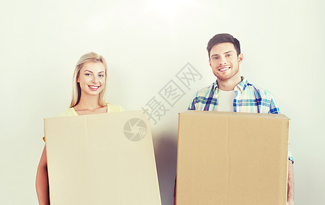 家,人,维修房地产微笑夫妇与大纸板箱搬新的地方微笑的夫妇带着大箱子搬新家图片