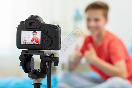 博客,技术人的相机记录视频快乐的微笑博客男孩家里竖大拇指家庭中博主男孩的相机录制视频图片