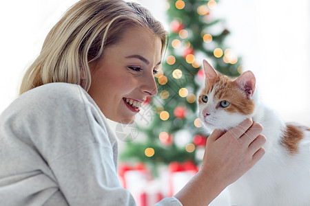 宠物,假期人的快乐的轻女人与猫诞树的背景快乐的轻女人猫诞节图片