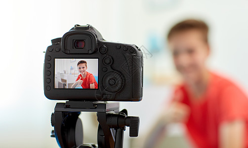 博客,技术人的相机记录视频快乐的微笑博客男孩家里竖大拇指家庭中博主男孩的相机录制视频图片