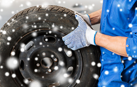 汽车服务,维修,维护人的汽车机械师更换轮胎车间雪上用汽车轮胎汽车机械师图片