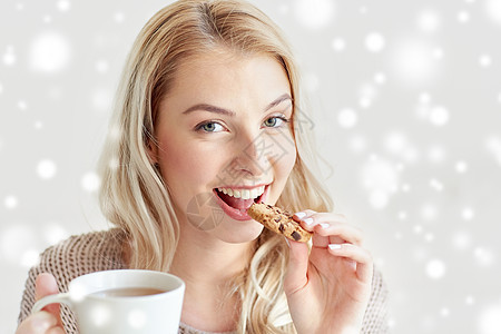 早上,早餐,食物人们的快乐的轻女人用杯茶雪地上吃饼干快乐的女人冬天喝茶吃饼干图片