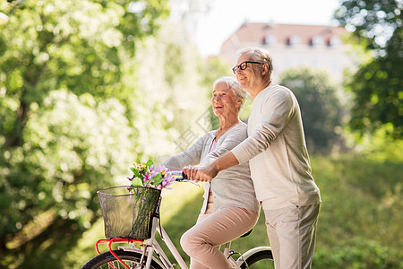 老,人生活方式的快乐的老夫妇与固定自行车夏季城市公园快乐的老夫妇夏季公园骑自行车图片