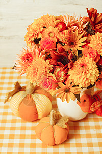 桌子上花小橙色纺南瓜的花瓶桌子上的秋天装饰图片