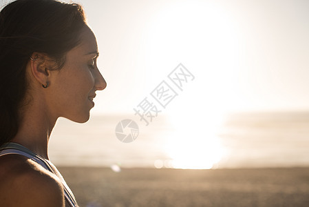 海滩上享受美丽日落的女人的肖像图片