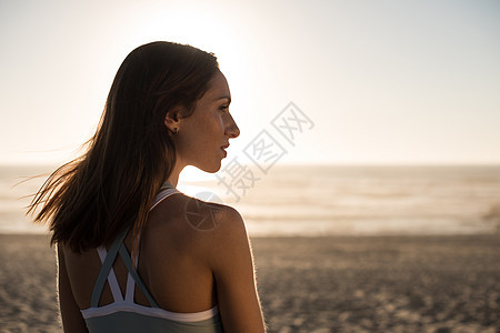 海滩上享受美丽日落的女人的肖像图片