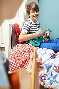 卧室里的孩子们弹吉他四弦琴图片