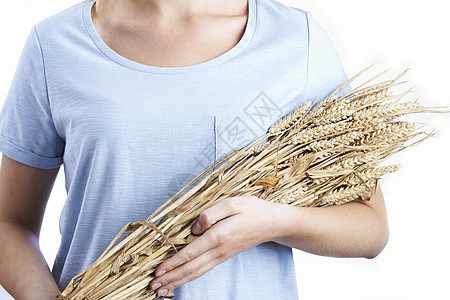 紧紧抱着捆小麦的女人背景图片