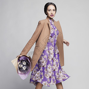 时尚工作室照片轻时尚的女人米色外套,紫丁香连衣裙,薰衣草花目录衣服看书图片