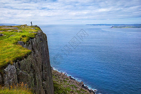 游客与背包站悬崖集市头,北爱尔兰,英国孤独的游客,背包站悬崖博览会的头上,看着拉特林岛,县安特里姆,英国图片