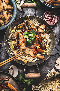 亚洲菜与鸡肉蔬菜条炒小锅与筷子烹饪配料,顶部视图图片