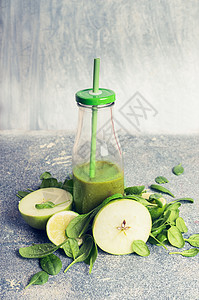 绿色冰沙瓶配料苹果菠菜,乡村背景,正观看,复古色调健康,饮食排饮料的图片