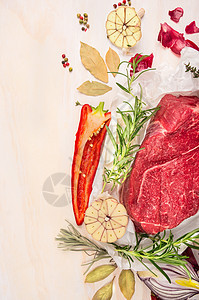 生肉与草药香料烹饪白色木制背景,顶部视图,框架图片