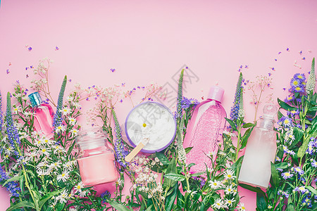 天然化妆品与新鲜草药花卉粉红色背景,顶部视图,边界美容,皮肤身体护理的图片
